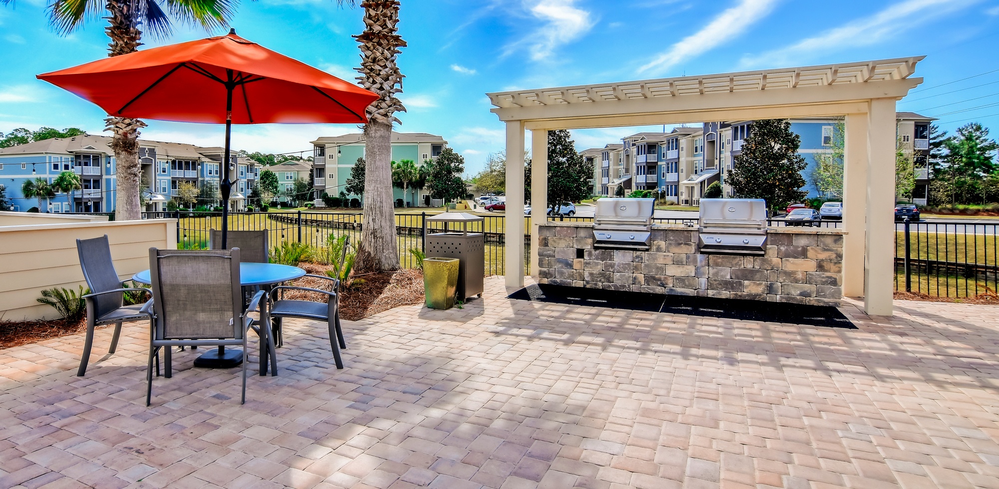 A patio with a table, chairs, and an umbrella.
